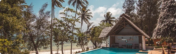 Pool Bar UPENDO – бар у бассейна, окруженный шезлонгами и пальмами.